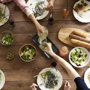 这张航拍照片显示，人们在摆满食物的桌子上伸手.