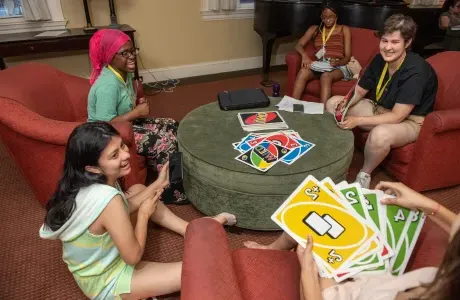学生们坐在房子的客厅里玩Uno.